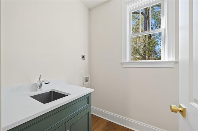 laundry room with cabinets, dark wood-type flooring, sink, and electric dryer hookup