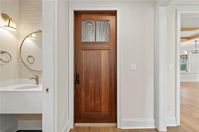 interior space with light hardwood / wood-style flooring, a notable chandelier, and sink