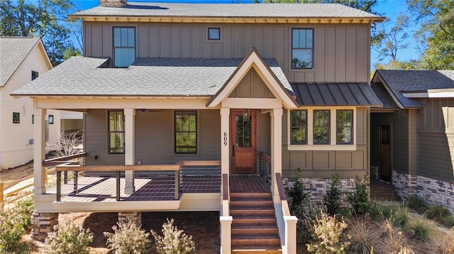 view of front of property with a standing seam roof, roof with shingles, board and batten siding, ceiling fan, and a porch