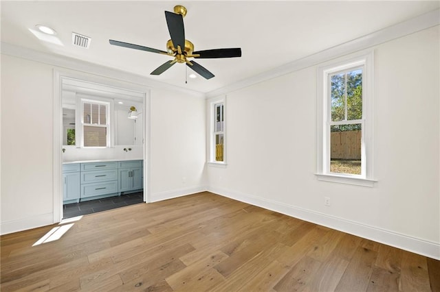 unfurnished bedroom with ceiling fan, light hardwood / wood-style flooring, connected bathroom, and crown molding