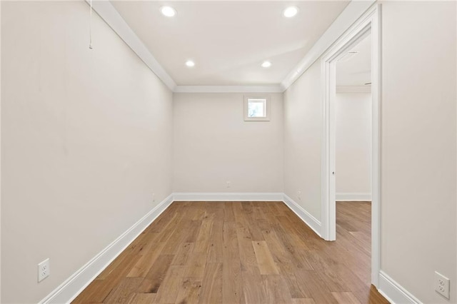 basement featuring recessed lighting, ornamental molding, baseboards, and wood finished floors
