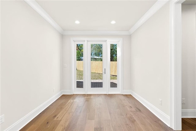 unfurnished room with baseboards, wood finished floors, and ornamental molding