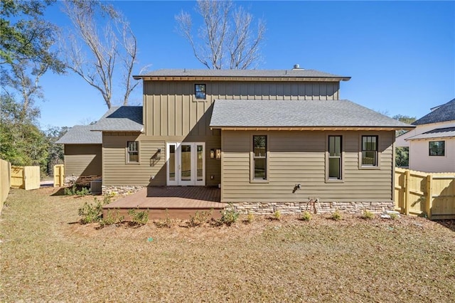 rear view of property featuring french doors, board and batten siding, a shingled roof, and fence
