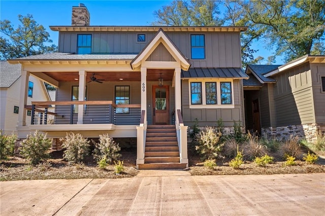 view of front facade with a chimney, board and batten siding, and a porch