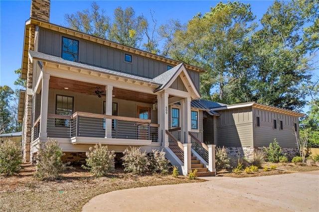 view of front of home featuring a chimney, covered porch, and board and batten siding