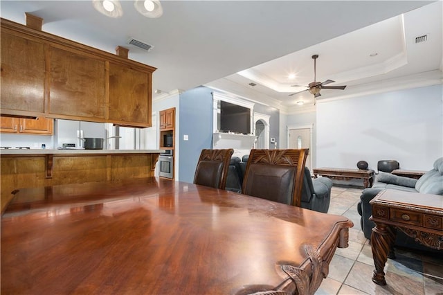 dining space with ceiling fan, light tile patterned floors, and a tray ceiling