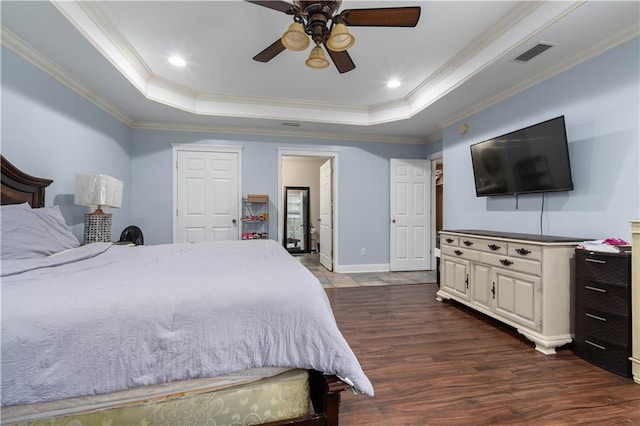 bedroom with crown molding, dark wood-type flooring, ceiling fan, and a raised ceiling