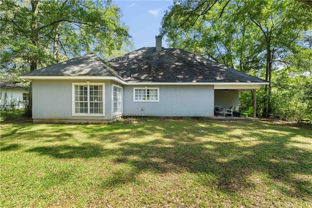 rear view of house with a patio and a lawn