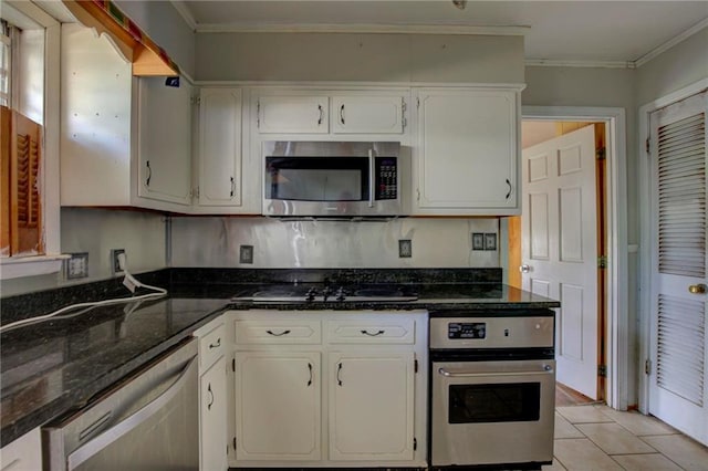 kitchen featuring white cabinetry, stainless steel appliances, light tile patterned floors, and ornamental molding