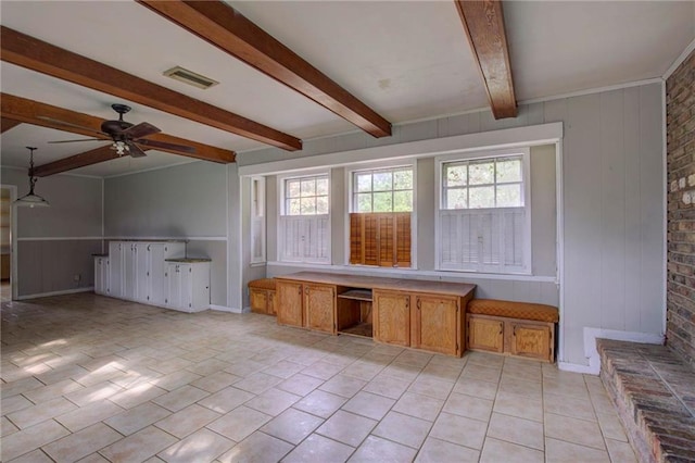 interior space with ceiling fan, beamed ceiling, and light tile patterned floors