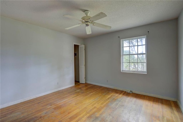 unfurnished room with ceiling fan, light hardwood / wood-style flooring, and a textured ceiling