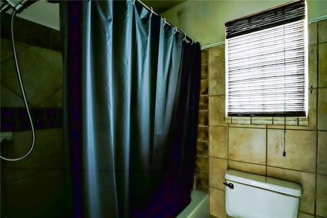 bathroom with shower / bath combination with curtain and toilet