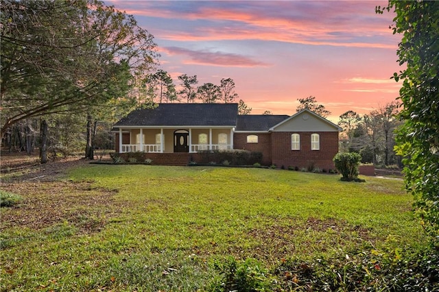 ranch-style home featuring a lawn and a porch