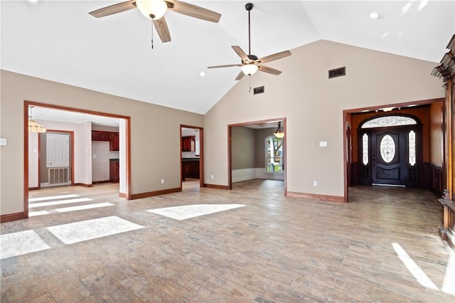 unfurnished living room with ceiling fan and high vaulted ceiling