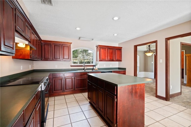 kitchen featuring stainless steel electric stove, a kitchen island, light tile patterned flooring, and a textured ceiling