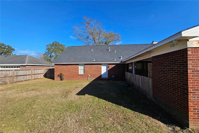 rear view of property featuring a lawn