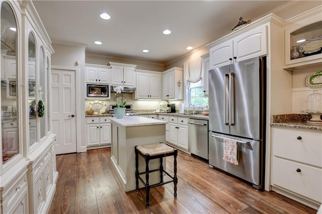 kitchen with a center island, white cabinetry, dark hardwood / wood-style flooring, and stainless steel appliances