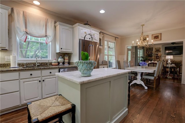 kitchen with dark hardwood / wood-style floors, light stone countertops, stainless steel appliances, sink, and white cabinetry