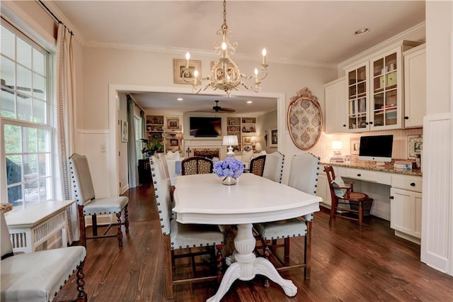 dining room with ceiling fan with notable chandelier, dark hardwood / wood-style floors, and crown molding