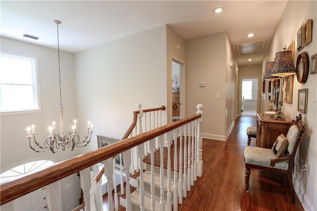 hallway featuring wood-type flooring and an inviting chandelier