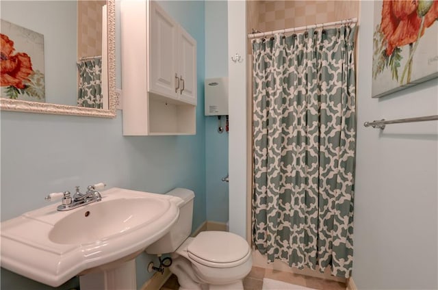 bathroom with water heater, sink, toilet, and tile floors