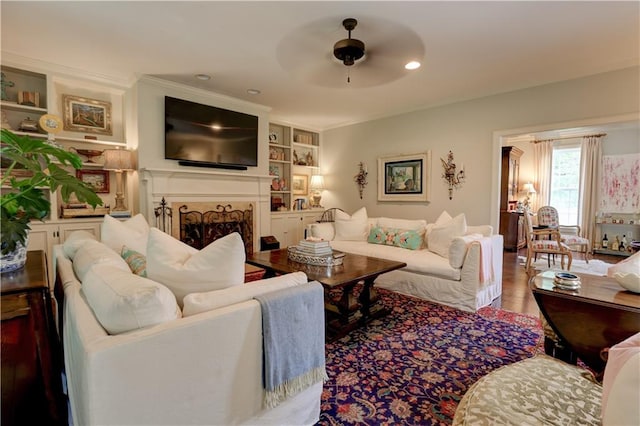 living room with ceiling fan, hardwood / wood-style flooring, and built in shelves