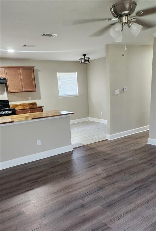 kitchen featuring black range oven, ceiling fan, and dark wood-type flooring