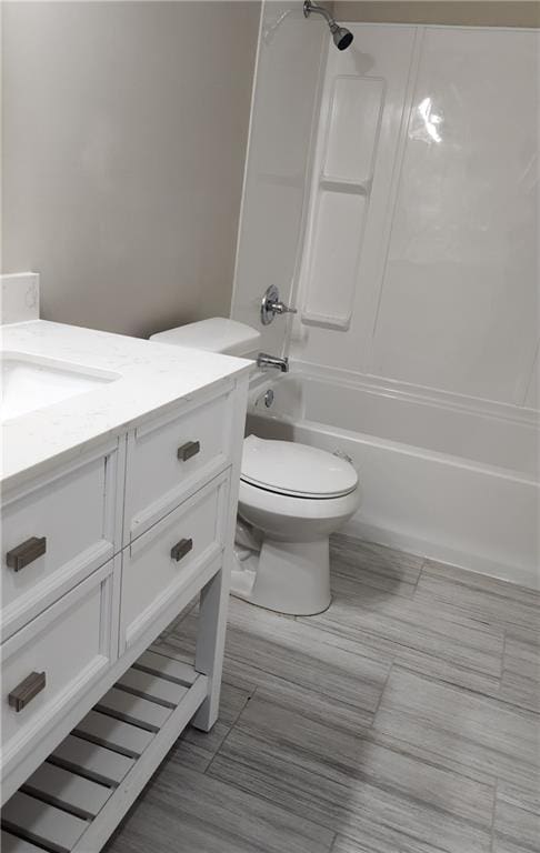 full bathroom featuring washtub / shower combination, vanity, and toilet