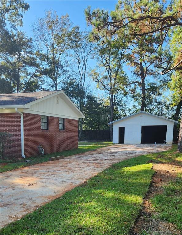 view of home's exterior with a yard, an outdoor structure, and a garage