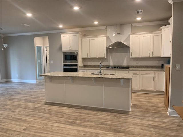 kitchen featuring white cabinets, sink, an island with sink, and stainless steel appliances