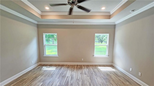 spare room with hardwood / wood-style floors, a raised ceiling, and ornamental molding