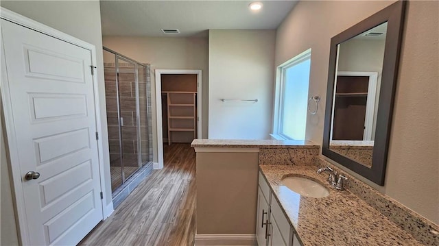 bathroom featuring a shower with door, vanity, and hardwood / wood-style flooring