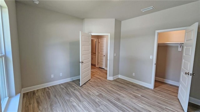 unfurnished bedroom featuring light hardwood / wood-style floors and a closet