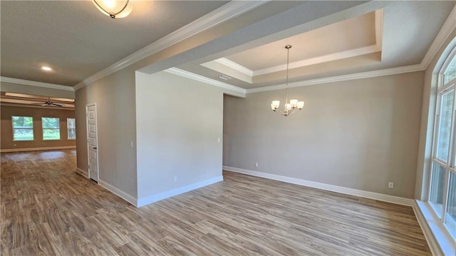 unfurnished room featuring wood-type flooring, crown molding, and a tray ceiling