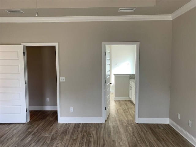 empty room with dark hardwood / wood-style flooring and ornamental molding