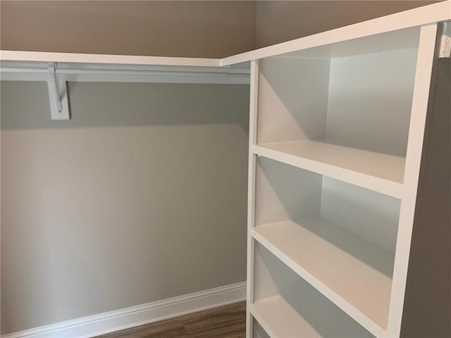 spacious closet with dark wood-type flooring