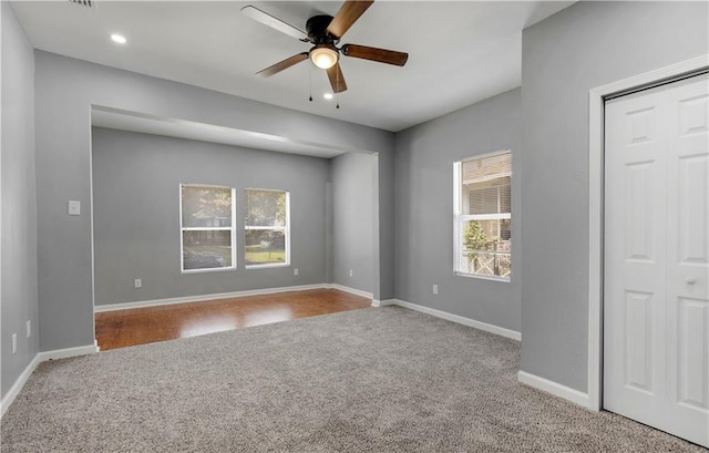 carpeted empty room featuring ceiling fan and a wealth of natural light