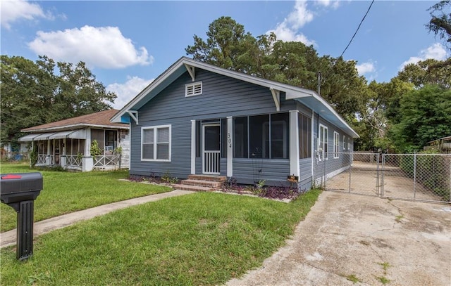 view of front of house with a sunroom and a front lawn