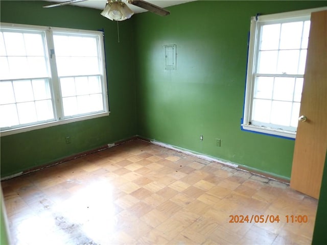 unfurnished room featuring a healthy amount of sunlight and ceiling fan