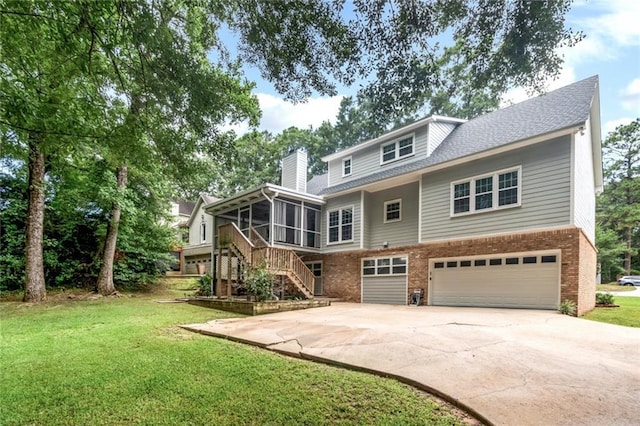 1509 Ridgeland Rd E, Mobile, AL 36695 - rear view of property with a sunroom, brick siding, an attached garage, and driveway
