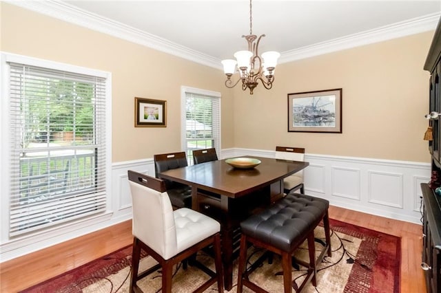 1509 Ridgeland Rd E, Mobile, AL 36695 - dining area featuring ornamental molding, a chandelier, a wainscoted wall, wood finished floors, and a decorative wall