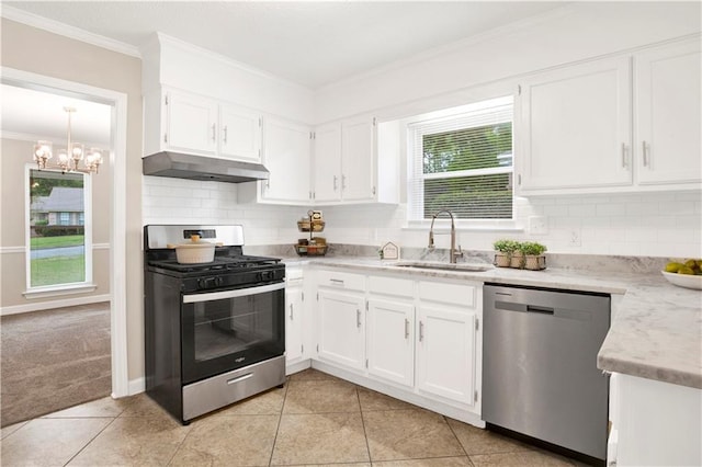 1115 Newbury Ln W, Mobile, AL 36695 - kitchen featuring appliances with stainless steel finishes, under cabinet range hood, crown molding, white cabinets, and backsplash