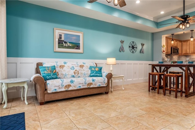 living area with a ceiling fan, recessed lighting, wainscoting, and ornamental molding