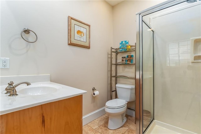 bathroom with a stall shower, vanity, toilet, and baseboards