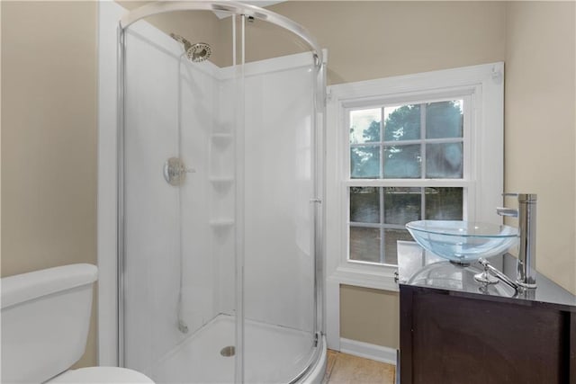 bathroom with toilet, vanity, tile patterned flooring, and a shower with door