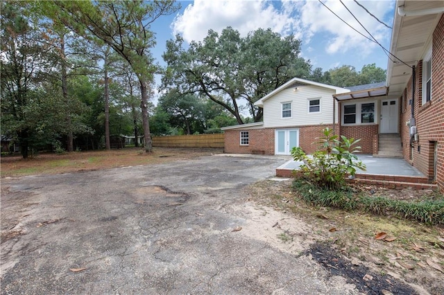 424 Byron Ave E, Mobile, AL 36609 - view of property exterior featuring brick siding, driveway, and fence