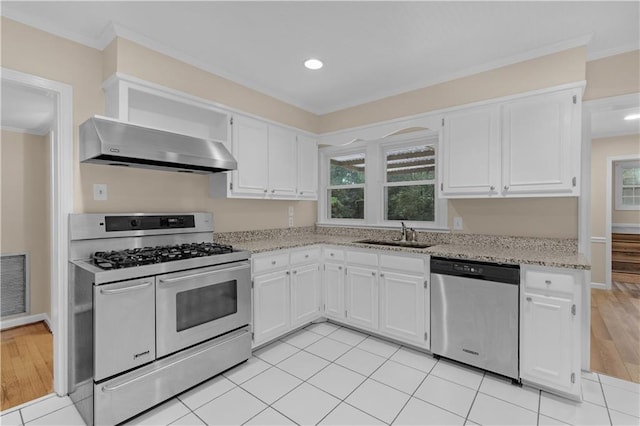 kitchen with stainless steel appliances, white cabinetry, extractor fan, sink, and light hardwood / wood-style flooring