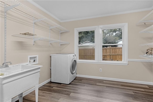 washroom with hardwood / wood-style flooring, crown molding, and washer / dryer