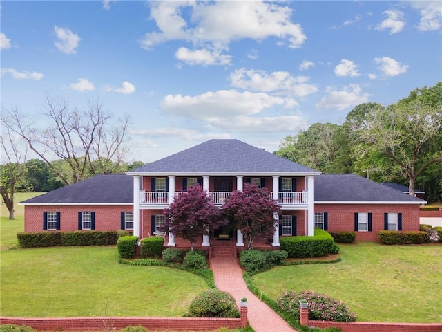 view of front of home with a balcony and a front lawn