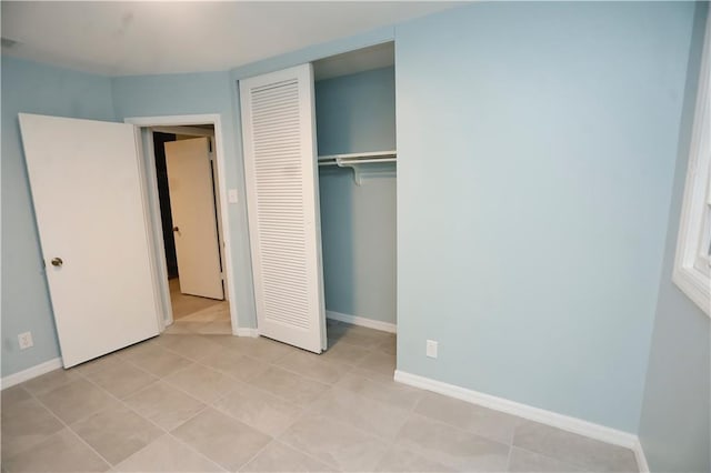 unfurnished bedroom with visible vents, a closet, baseboards, and light tile patterned floors